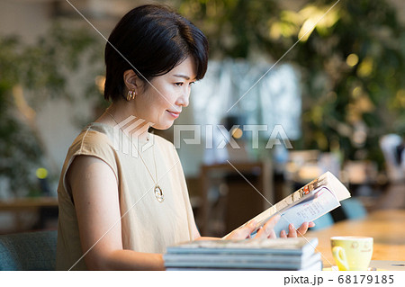 カフェで雑誌を読む40代女性 68179185