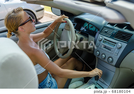 Woman driving on a parking lot 68180104