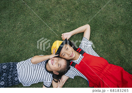 Flat lay - two thai little girl laying on grass 68183265