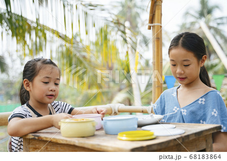 Two sisters eating together from Pinto. Two sisters eating together from Pinto. 68183864