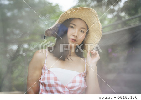 Thai woman on pink dress wearing big hat in nature Thai woman on pink dress wearing big hat in nature 68185136