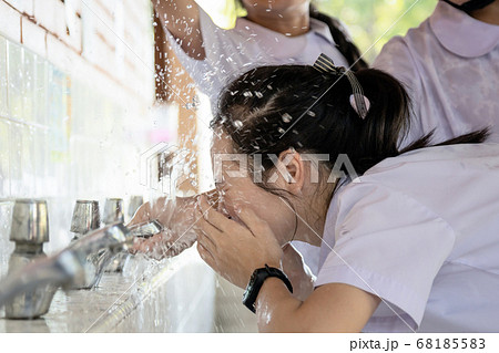 Group of her friends likes to bullying,sad child girl is bullied by splash of water on her face while washing her face,schoolgirl that got completely drenched,girl student getting bullying in school Group of her friends likes to bullying,sad child girl is bullied by splash of water on her face while washing her face,schoolgirl that got completely drenched,girl student getting bullying in school 68185583