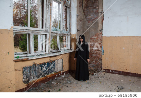 young goth woman stands in the room of an young goth woman stands in the room of an 68185900