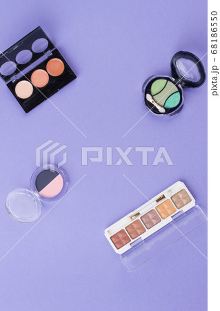 Vaarious cosmetic powders on a purple background. 68186550