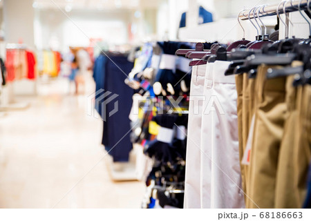 Trousers hang on rails in modern clothes shop 68186663