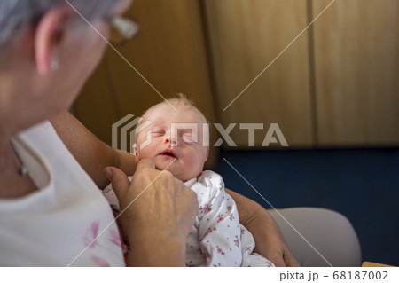 A woman holding sleeping newborn baby 68187002