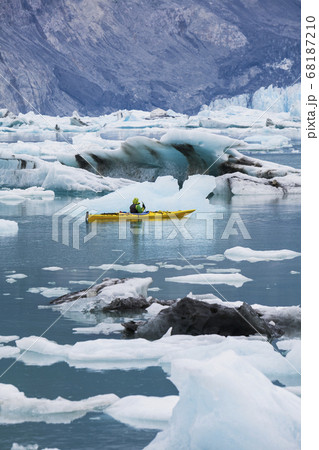 Sea kayaker paddling in glacial lagoon at a glacier terminus on the coast of Alaska Sea kayaker paddling in glacial lagoon at a glacier terminus on the coast of Alaska 68187210