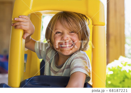 portrait of smiling 4 year old boy with chocolate on his face playing with older sister portrait of smiling 4 year old boy with chocolate on his face playing with older sister 68187221