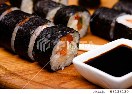 Sushi with salmon. Soy sauce, red caviar. Sushi on a black background. 68188180