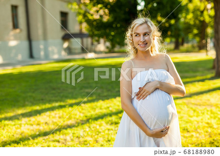 Portrait of a happy pregnant woman in a park 68188980