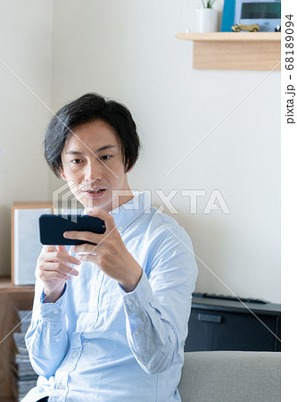 スマホで動画配信を見る男性 68189094