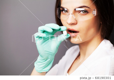 Doctor in a white coat holding a pill for a healthy sex life of men. 68190301