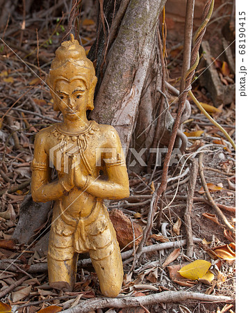 Crack old buddha statue under the tree on ground Crack old buddha statue under the tree on ground 68190415