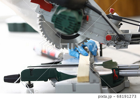 Hands holding a wooden block for sawing on machine Hands holding a wooden block for sawing on machine 68191273