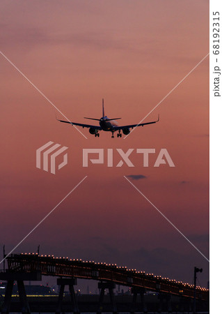 夕焼けの時間帯に着陸する飛行機 夕焼けの時間帯に着陸する飛行機 68192315