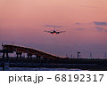 夕焼けの時間帯に着陸する飛行機 68192317
