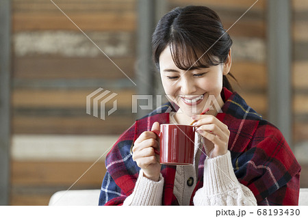 温かい飲み物の入ったマグカップを持つ若い女性 温かい飲み物の入ったマグカップを持つ若い女性 68193430