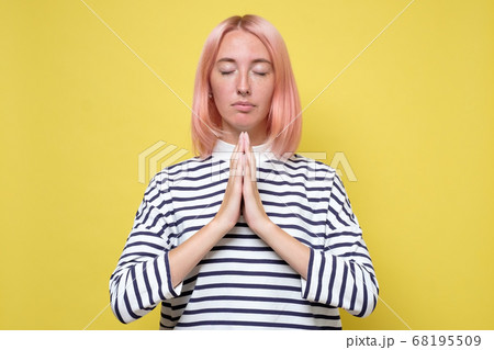 Beautiful casually dressed young woman praying 68195509