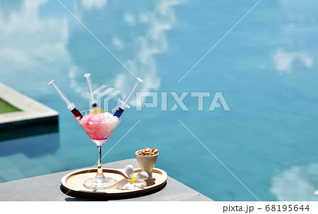 Drink a cocktail on vacation at the swimming pool 68195644