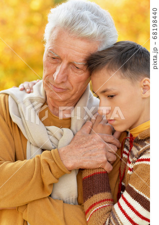 Portrait of sad grandfather and grandson hugging 68198440