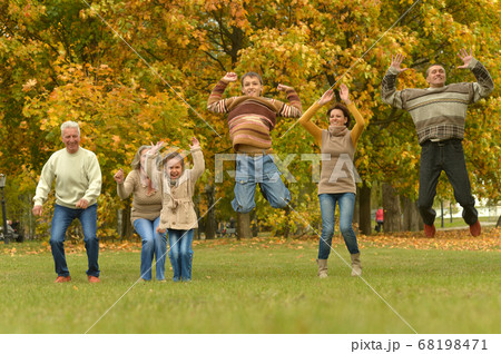 Happy smiling family relaxing in autumn park jumping Happy smiling family relaxing in autumn park jumping 68198471