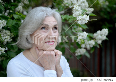 Happy senior beautiful woman with lilacs in spring park 68198493