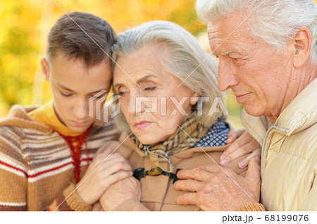 Portrait of sad grandfather, grandmother and grandson hugging 68199076