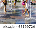 Children splashing in the city fountain. Hot summer day. 68199720