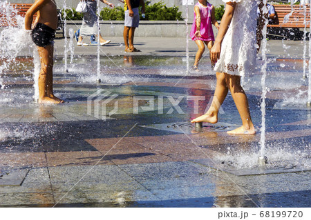 Children splashing in the city fountain. Hot summer day. 68199720