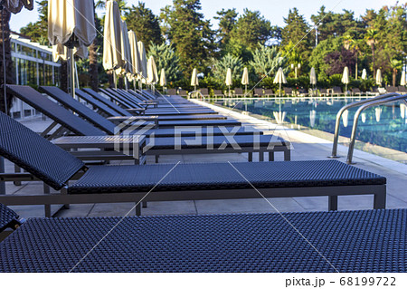 Sun beds by the pool in the open air. Pool at the spa resort. 68199722