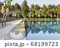 Sun beds by the pool in the open air. Pool at the spa resort. 68199723