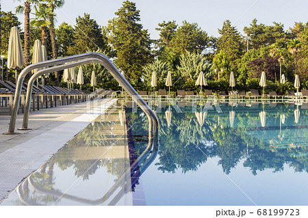 Sun beds by the pool in the open air. Pool at the spa resort. 68199723