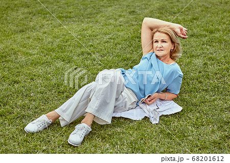 Aged pretty lady has rest outdoor. 68201612