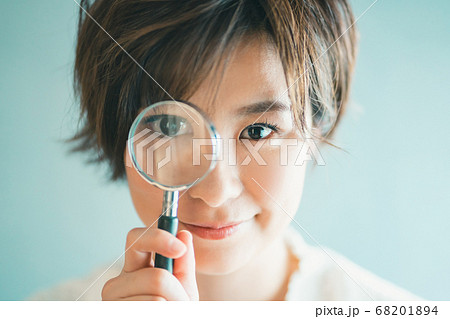 虫眼鏡を覗き込むアラサー女子 虫眼鏡を覗き込むアラサー女子 68201894