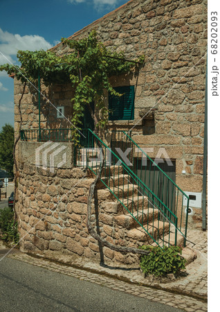 Old stone house with staircase leading to a porch in Monsanto 68202093