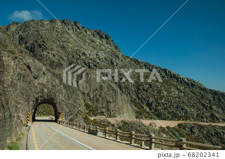 Road on rocky landscape passing through tunnel 68202341