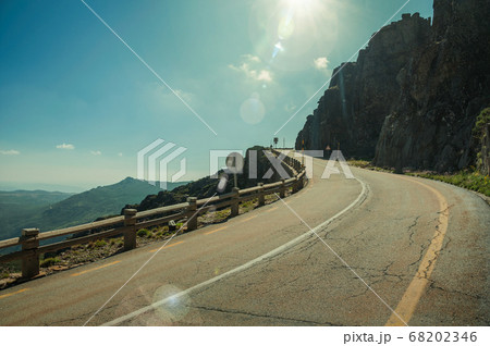 Road passing through rocky landscape in a sunny day Road passing through rocky landscape in a sunny day 68202346