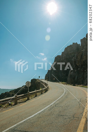 Road passing through rocky landscape in a sunny day 68202347