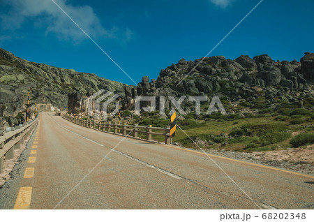 Roadway passing through rocky landscape 68202348