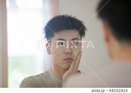 鏡で自分を見る男性 68202824