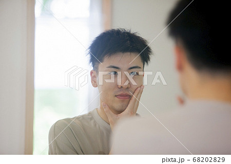 鏡で自分を見る男性 68202829