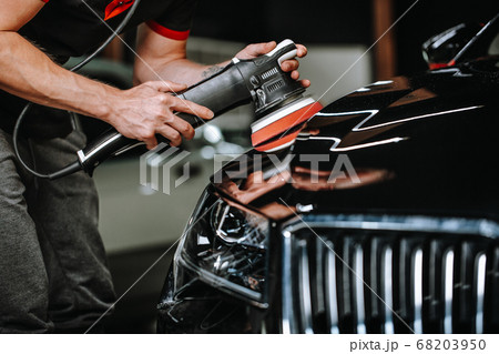 Professional detailing a car in car studio, hands with orbital polisher, scratching remover, vehicle care concept 68203950