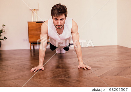 Muscular Athletic Fit Man is Doing Push Up Exercises at Home in His Bright Apartment with Minimalistic Interior 68205507