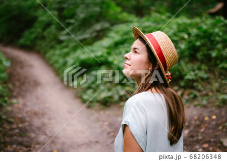 Outdoor photo of exciting girl chilling in a beautiful forest. Joyful young pretty woman in vintage straw hat posing in the park. Pretty young lady walking in the forest. Every step is an adventure Outdoor photo of exciting girl chilling in a beautiful forest. Joyful young pretty woman in vintage straw hat posing in the park. Pretty young lady walking in the forest. Every step is an adventure 68206348