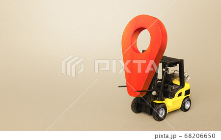 Yellow forklift carries a red location pointer. Transportation services and logistics management warehouse. Destination cargo and parcels, tracking. Efficient express delivery system. 68206650