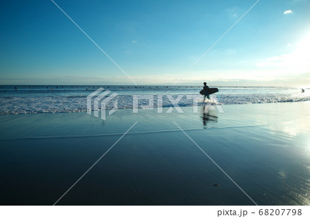 空と海と砂浜 そして人のシルエットがきれいです の写真素材