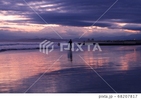 空と海と砂浜 そして人のシルエットがきれいです の写真素材