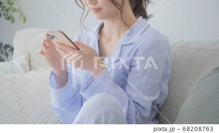 パジャマでスマホを操作する若い女性　朝 68208763