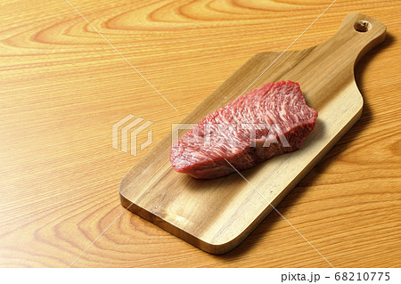 カッティングボードの上に置かれた焼く前の牛肉 68210775