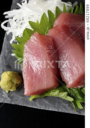 スレートプレートの上には大根のツマ、大葉、ワサビそして中トロのお刺身が乗っています（黒背景、俯瞰） 68217899